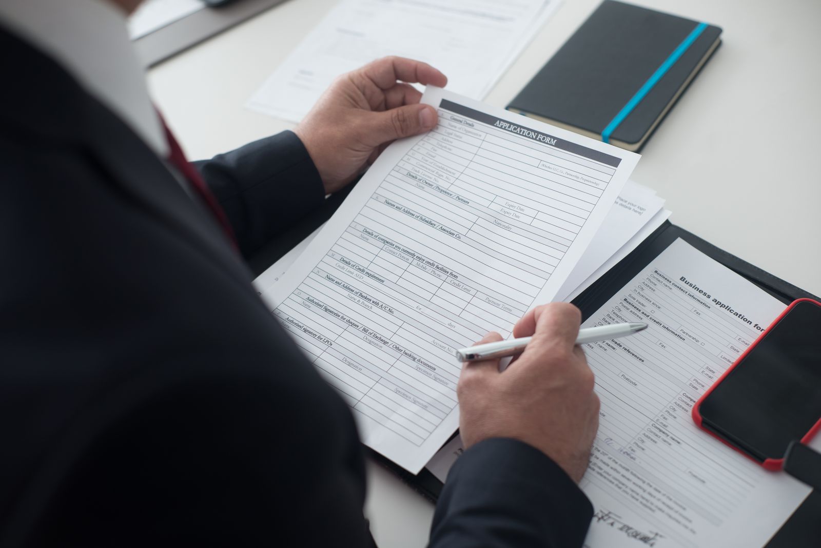 Person checking paperwork at a desk
